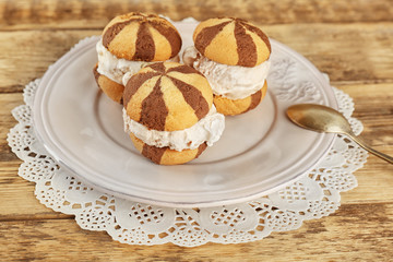 Ice cream cookie sandwiches on plate on wooden background