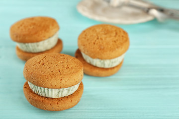 Obraz na płótnie Canvas Ice cream cookie sandwiches with fresh mint on blue wooden background