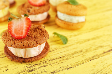 Ice cream cookie sandwiches on yellow wooden background