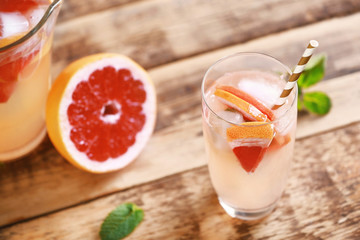 Glass of fresh grapefruit water on wooden background