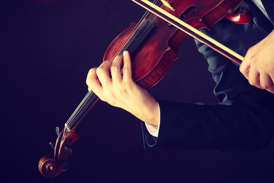 Man man dressed elegantly playing violin