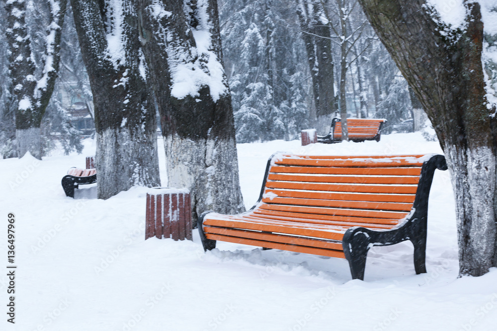 Sticker empty bench covered with snow in winter park