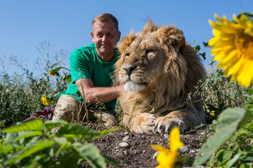 The man hugging the lion in safari park Taigan, Crimea, Russia