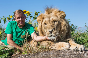 The man hugging the lion in safari park Taigan, Crimea, Russia
