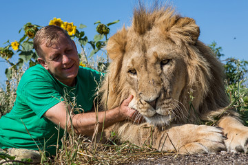 The man hugging the lion in safari park Taigan, Crimea, Russia