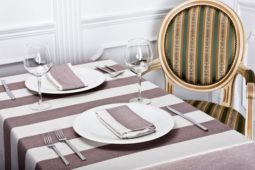 Beautiful decorated table with linen napkins, cutlery on luxurious tablecloth