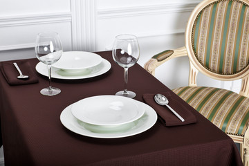 Beautiful decorated table with linen napkins, cutlery on luxurious tablecloth
