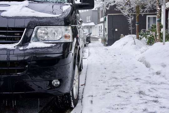 Kleinbus/Van parkt an Stra&szlig;enrand im verschneiten Winterberg