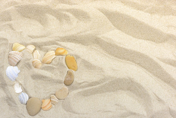 Fototapeta na wymiar Heart on Sea Sand from pebbles and shells for background