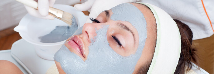 Young woman with natural facial mask in beauty spa