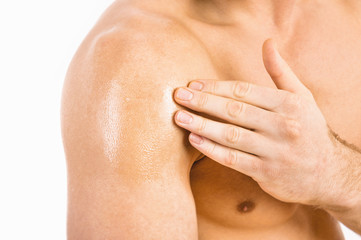Testosterone Replacement Therapy (TRT) - Muscular man applying testosterone gel on shoulder