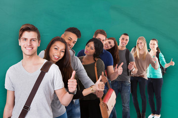 Fototapeta na wymiar Student Standing In Row Against Green Background