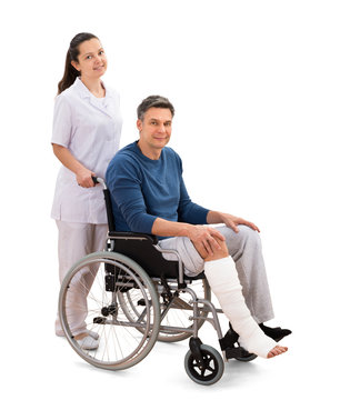 Female Nurse With Disabled Patient On Wheelchair