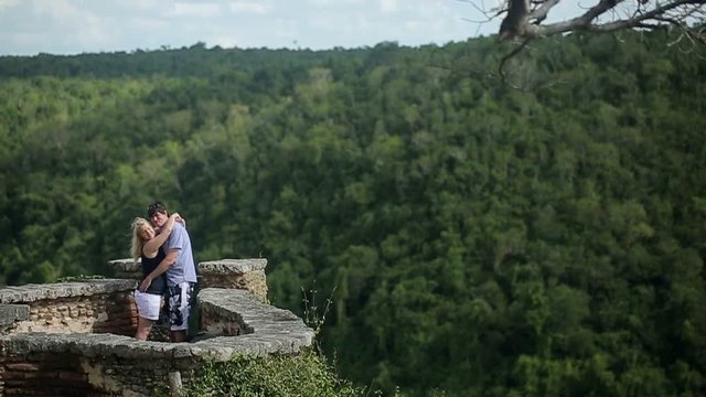 Young lovely couple embracing on medieval wall shot