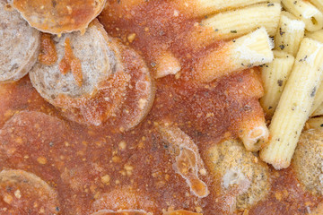 Close view of frozen rigatoni pasta with meatballs and sausage.