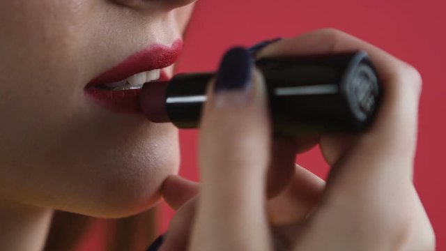 girl paints her lips close-up