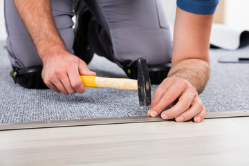 Person's Hand Using Hammer And Nail