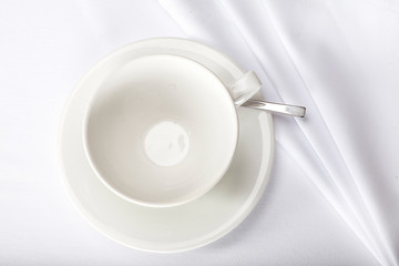 top view of a teacup on a white tablecloth