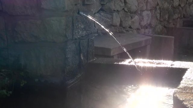 sunlight and woman hand on the water of drinking fountain-Dan