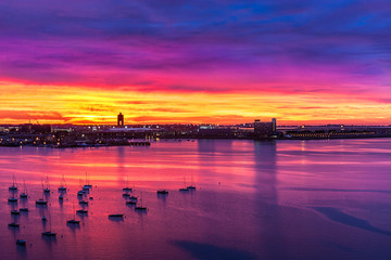 Vivid skies before sunrise with boats at anchor in Boston harbor  - obrazy, fototapety, plakaty