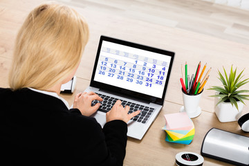Fototapeta na wymiar Businesswoman Looking At Calendar On Laptop