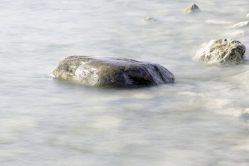 Soft misty waters flowing over icy rocks, peaceful winter