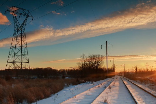 winter landscape transmission line on of bright red sunset