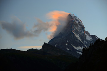 Matterhorn in early morning with alpenglow and cloud on peak in