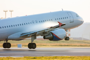 Fototapeta na wymiar Taking off passenger airplane with condensate vapor on wings