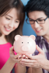  couple hold pink piggy bank