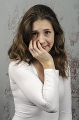 Portrait of a young brown-haired woman with a romantic curly hair in a white blouse
