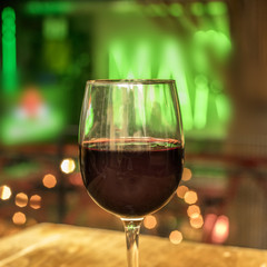 Glass of red wine on blurred lights background