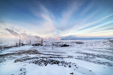Winter landscape with the smoking pipes of steel works.