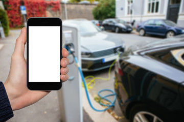 Hand with phone on a background of electric cars charging points. White screen, you can insert your own image or text here.
