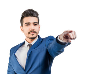 Fototapeta premium Young attractive man in a blue suit showing a finger forward on a white background. Isolated