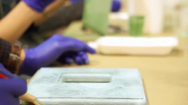 Master paints brush frame in a creative workshop. Slow motion.