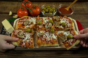 Children's hands are served with pizza