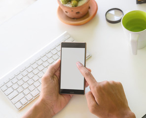 hand using phone on worktable