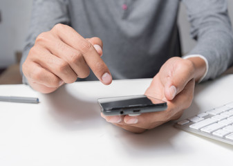 hand using phone on worktable