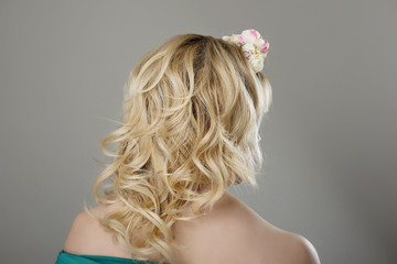head of a woman with curly hair on gray isolated background