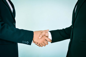 Businesswomen shake hand in office, selective of focus and blue background