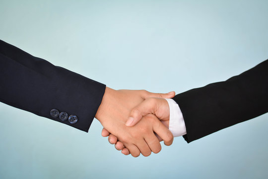Businesswomen shake hand in office, selective of focus and blue background