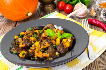 Roasted vegetables with pumpkin and mushrooms on a black plate