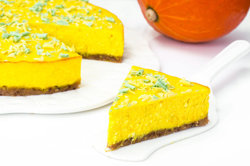 Delicious bright orange homemade american pumpkin pie on a white