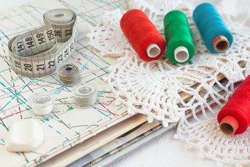Accessories for sewing.Multi-colored thread,scissors,measuring tape,bobbins,pattern.