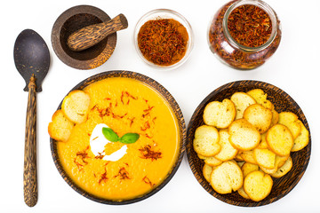 Vegetable cream soup with saffron and croutons on white backgrou