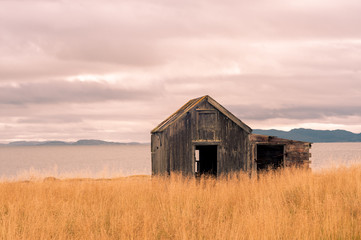 Abandoned wooden cottage cabin in the countryside with sea