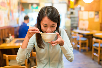 Woman eating soup in japanese restaurant