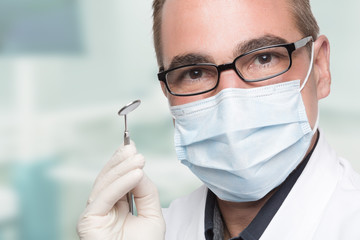 Zahnarzt mit Zahnspiegel mit Zahnarztpraxis im HIntergrund