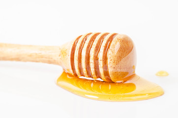 Honey dripping with honey stick.